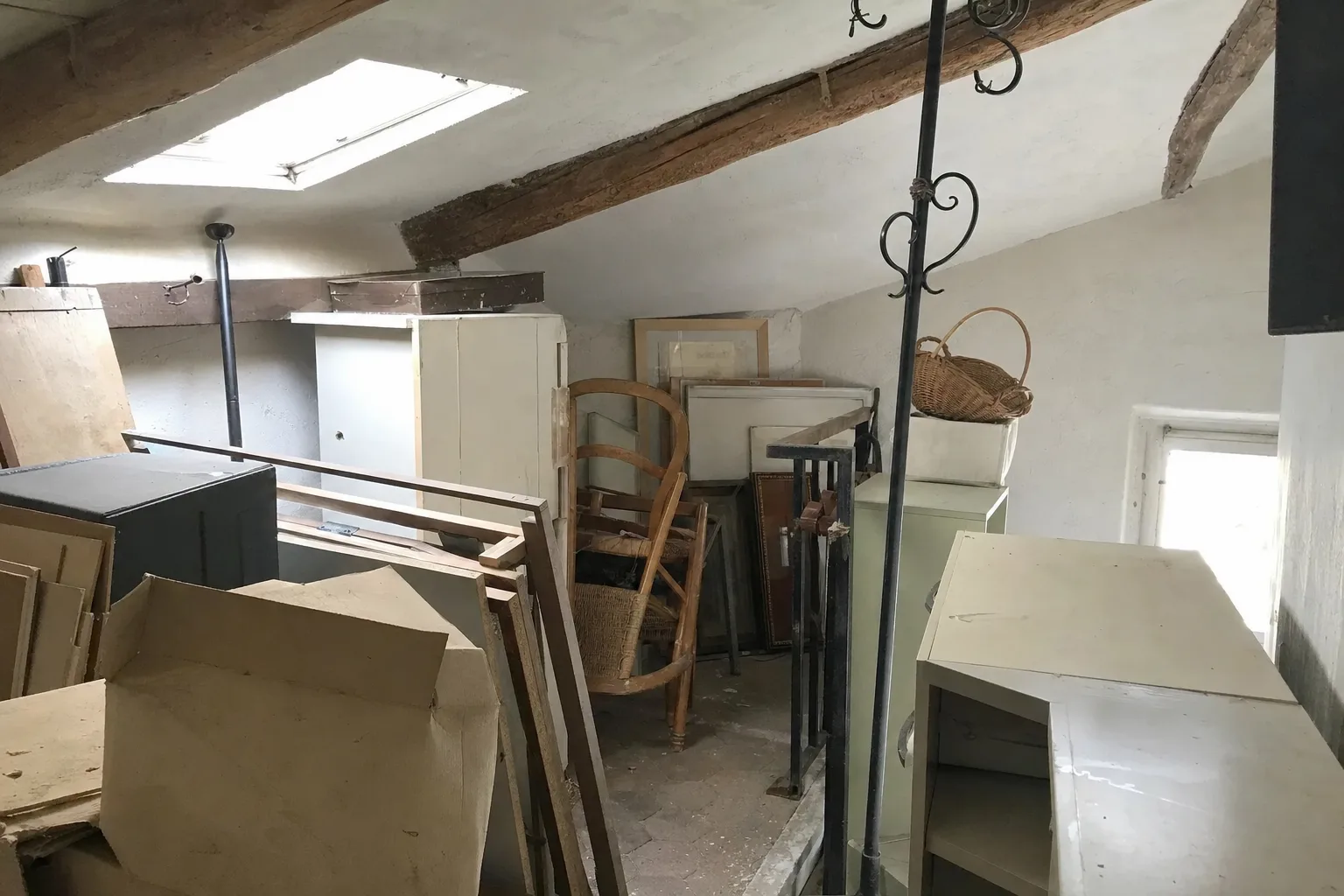 Grenier sous les toits encombré de meubles et de cartons