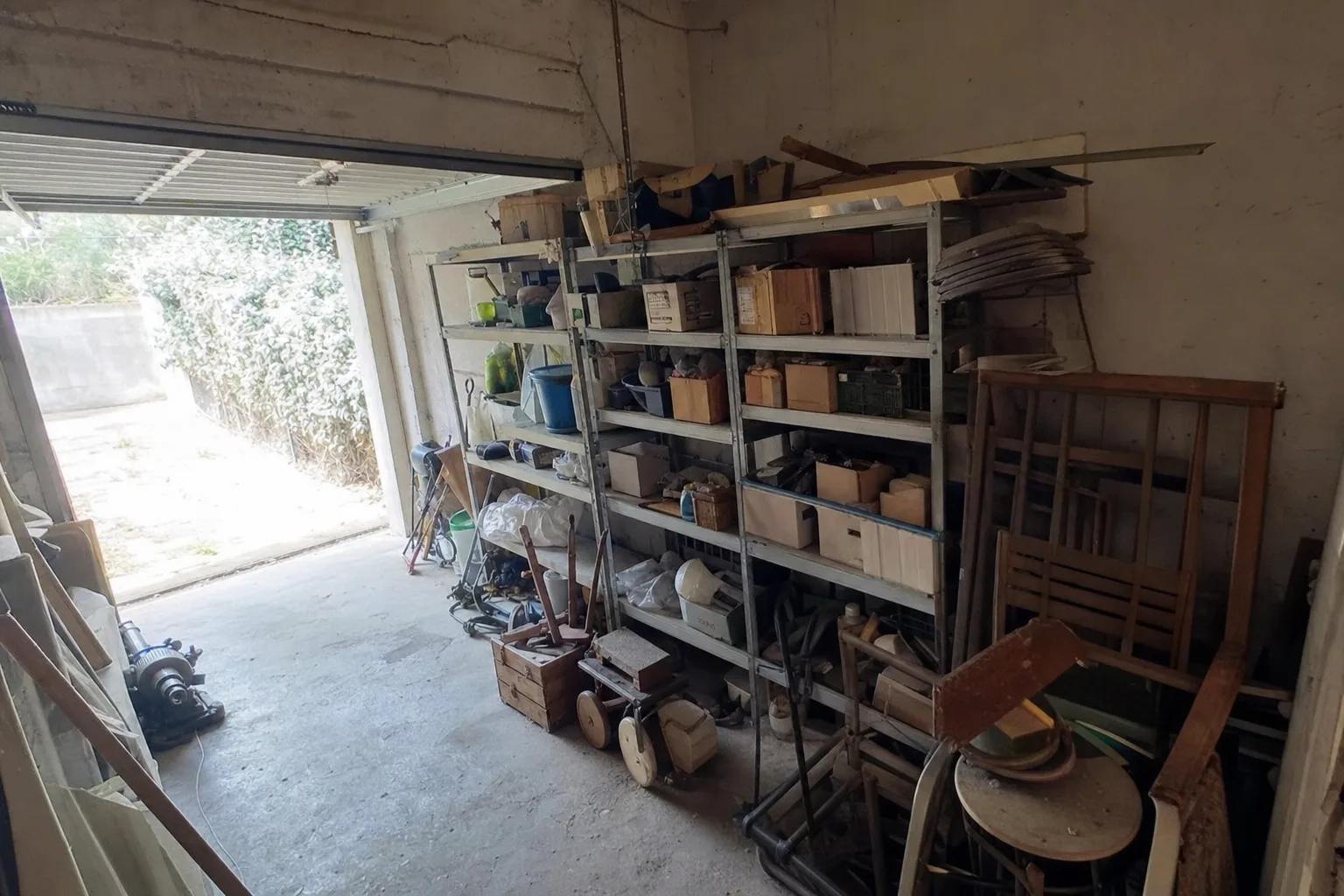 Garage encombré de cartons, outils et vieux meubles