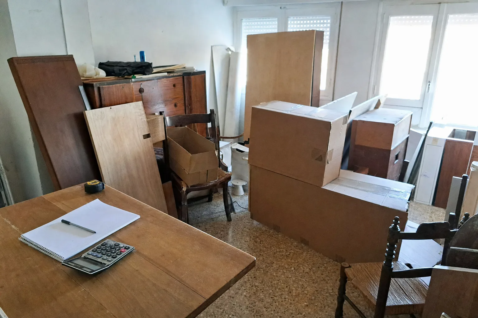 Meubles et cartons avec un mètre ruban, estimation du volume d'un débarras