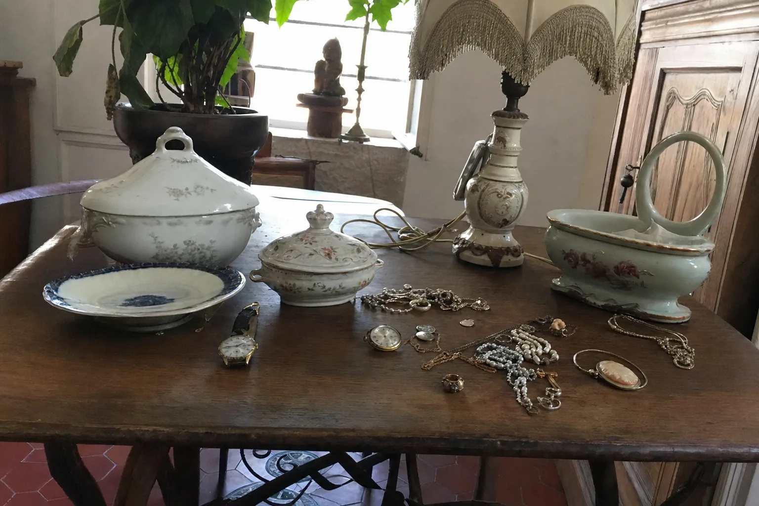Objets de valeur sur une table : montre, bijoux, porcelaine